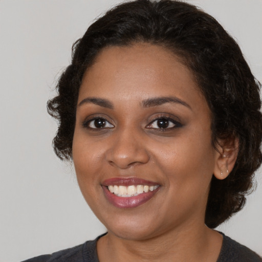 Joyful black young-adult female with medium  brown hair and brown eyes