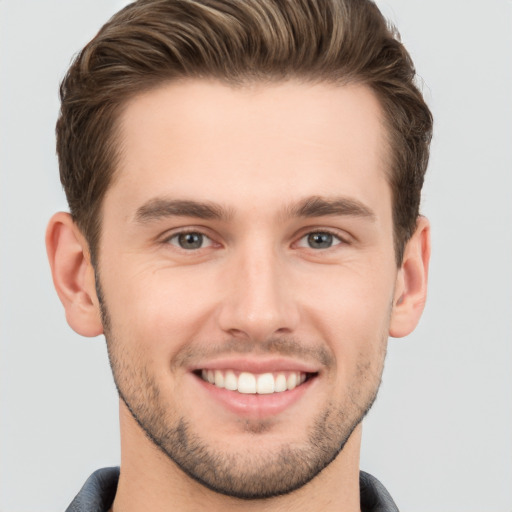 Joyful white young-adult male with short  brown hair and grey eyes