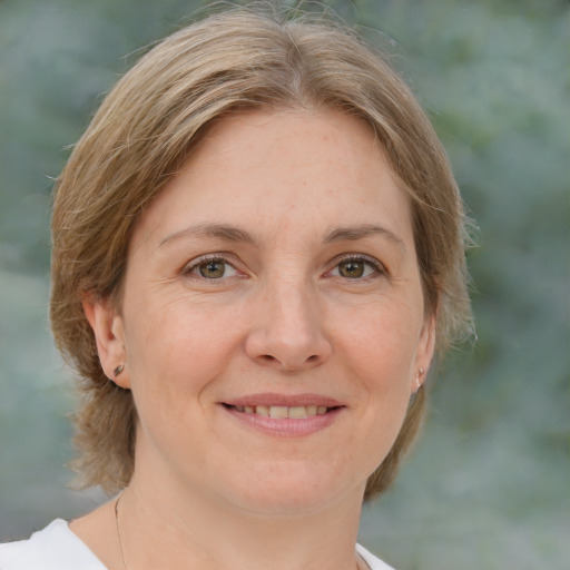 Joyful white adult female with medium  brown hair and green eyes