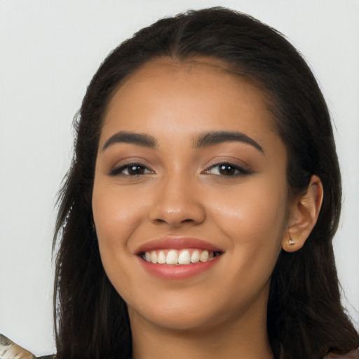 Joyful latino young-adult female with long  brown hair and brown eyes