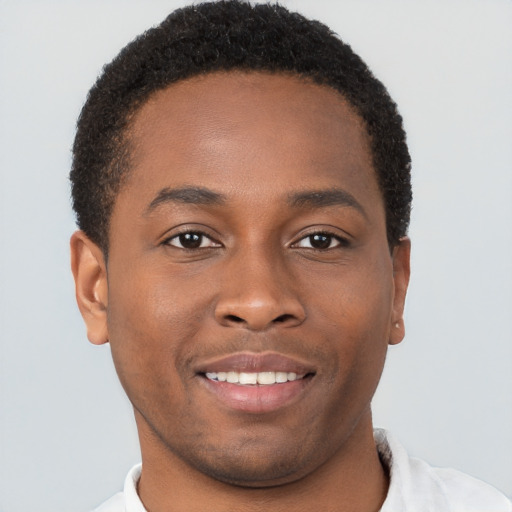 Joyful black young-adult male with short  brown hair and brown eyes