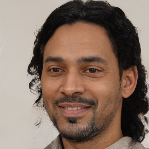 Joyful latino adult male with short  black hair and brown eyes