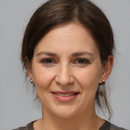 Joyful white adult female with medium  brown hair and brown eyes