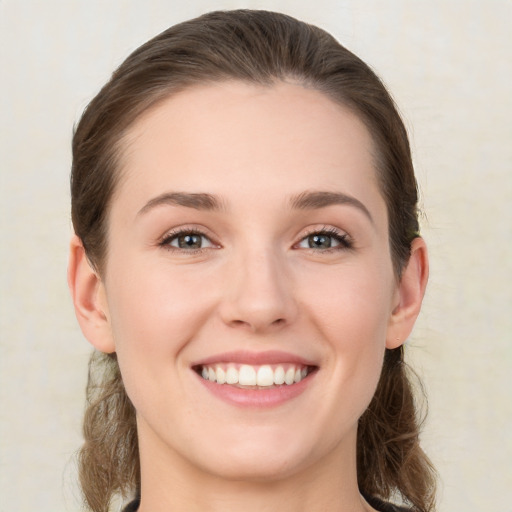 Joyful white young-adult female with medium  brown hair and green eyes