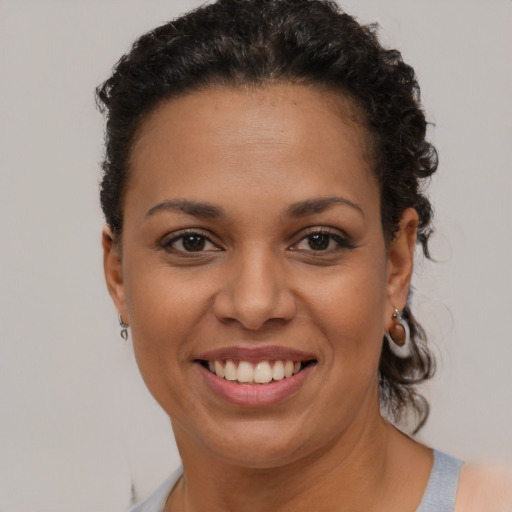 Joyful black young-adult female with short  brown hair and brown eyes
