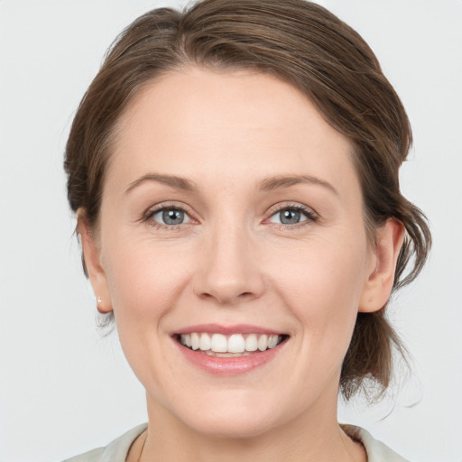 Joyful white young-adult female with medium  brown hair and grey eyes