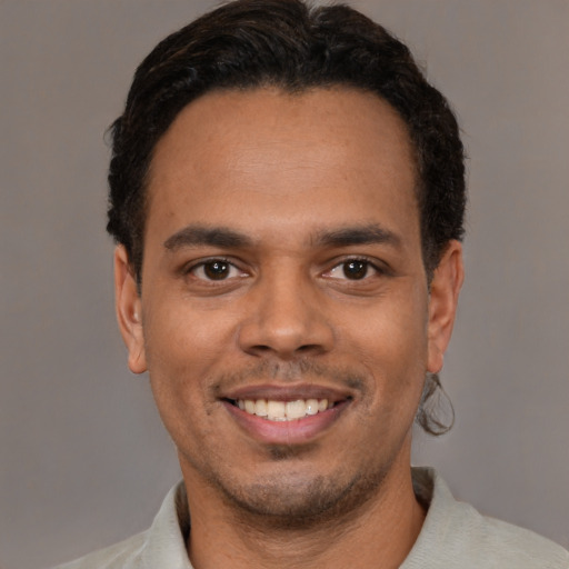 Joyful white young-adult male with short  black hair and brown eyes