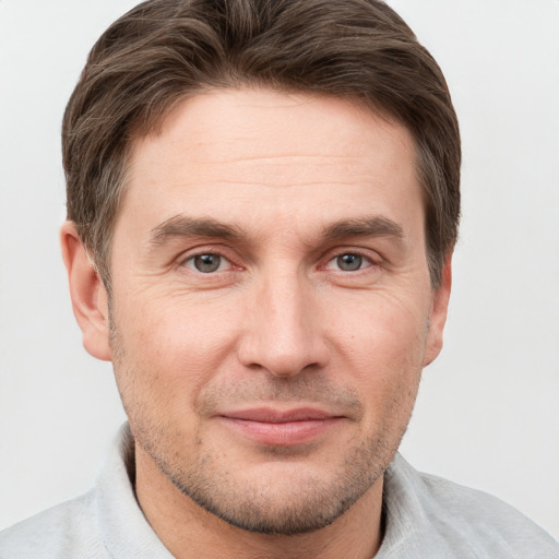 Joyful white adult male with short  brown hair and grey eyes