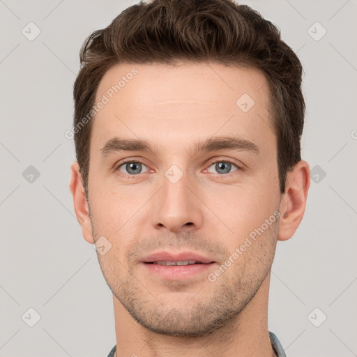 Joyful white young-adult male with short  brown hair and grey eyes