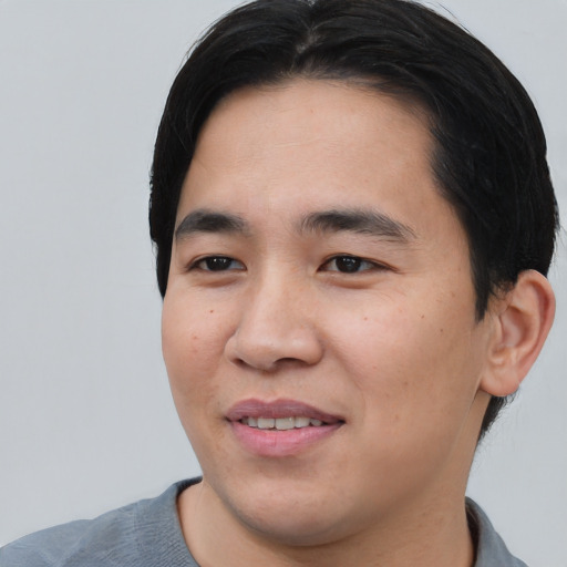Joyful asian young-adult male with short  black hair and brown eyes
