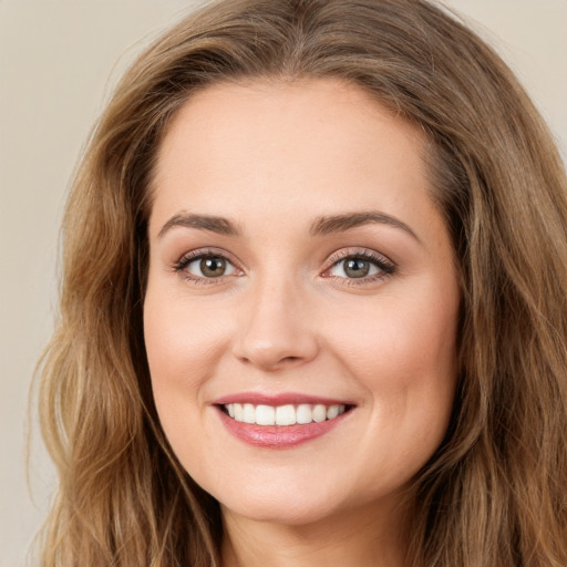 Joyful white young-adult female with long  brown hair and green eyes