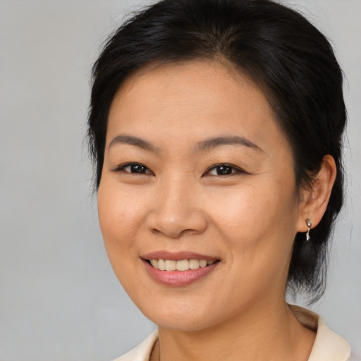 Joyful asian young-adult female with medium  brown hair and brown eyes