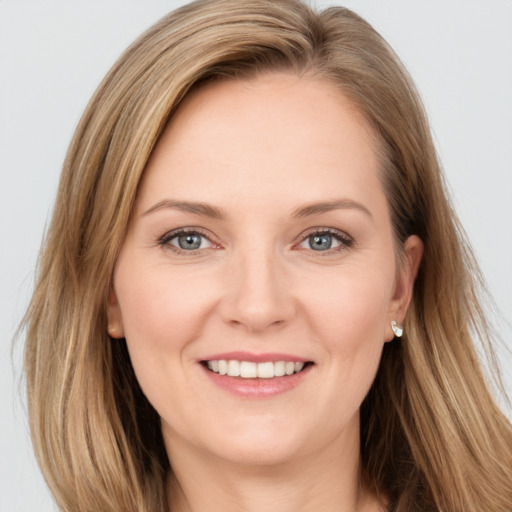 Joyful white young-adult female with long  brown hair and blue eyes