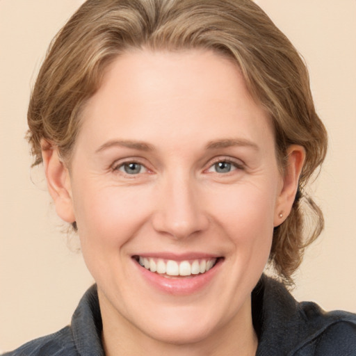 Joyful white adult female with medium  brown hair and grey eyes