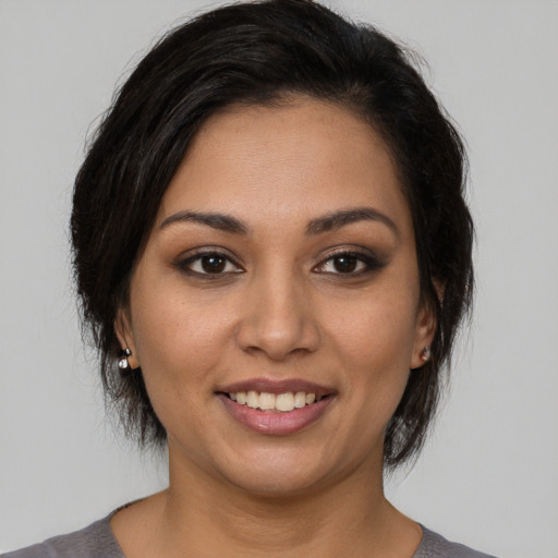 Joyful latino young-adult female with medium  brown hair and brown eyes
