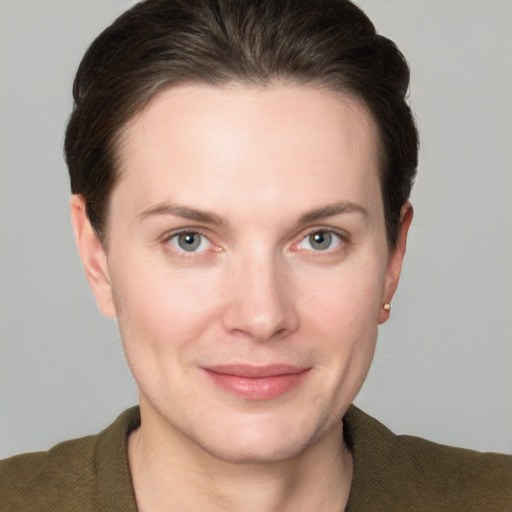 Joyful white young-adult female with short  brown hair and grey eyes