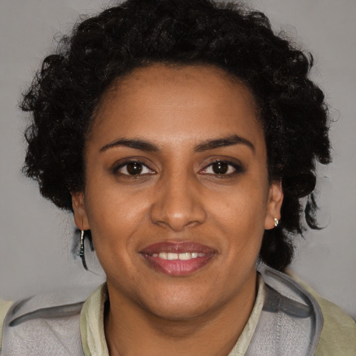 Joyful black adult female with short  black hair and brown eyes