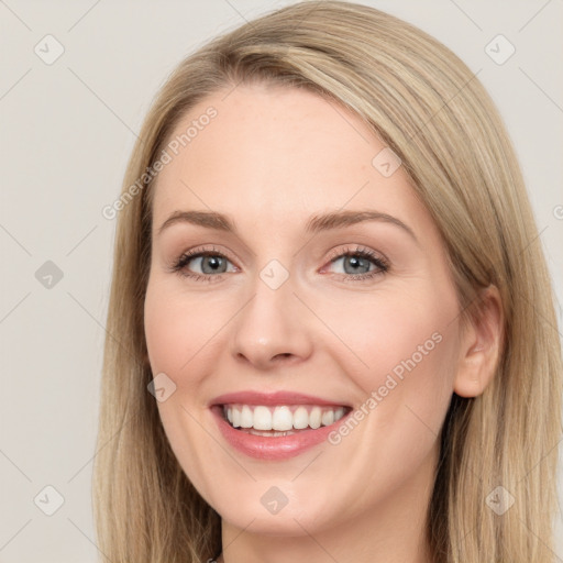 Joyful white young-adult female with long  brown hair and blue eyes