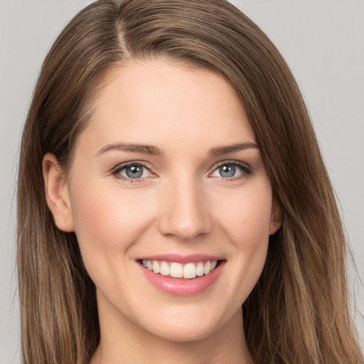 Joyful white young-adult female with long  brown hair and grey eyes