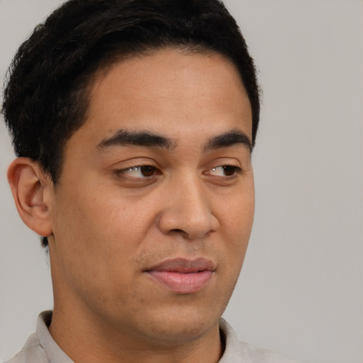 Joyful latino young-adult male with short  brown hair and brown eyes