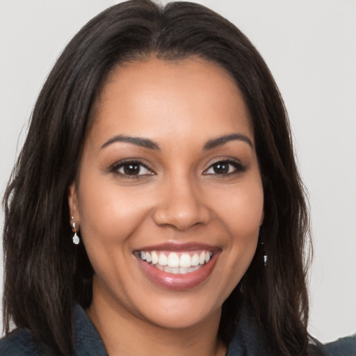 Joyful latino young-adult female with long  brown hair and brown eyes