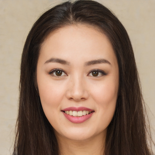 Joyful asian young-adult female with long  brown hair and brown eyes
