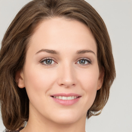 Joyful white young-adult female with medium  brown hair and green eyes