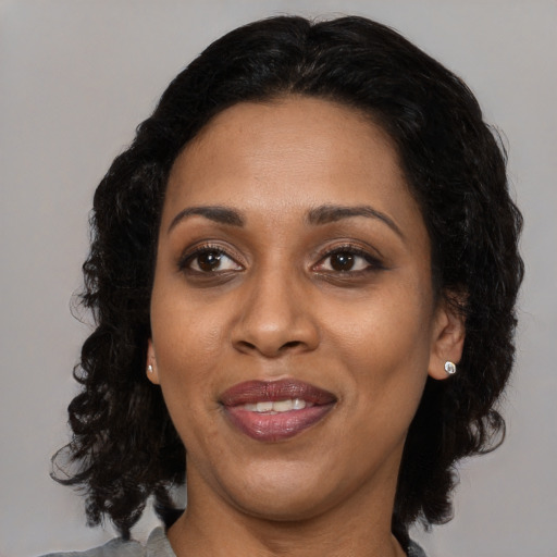 Joyful black adult female with medium  brown hair and brown eyes