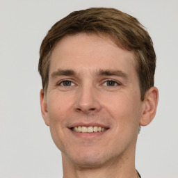 Joyful white young-adult male with short  brown hair and grey eyes