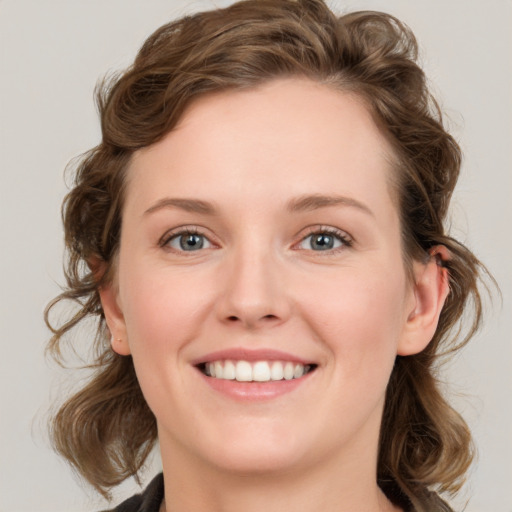 Joyful white young-adult female with medium  brown hair and blue eyes