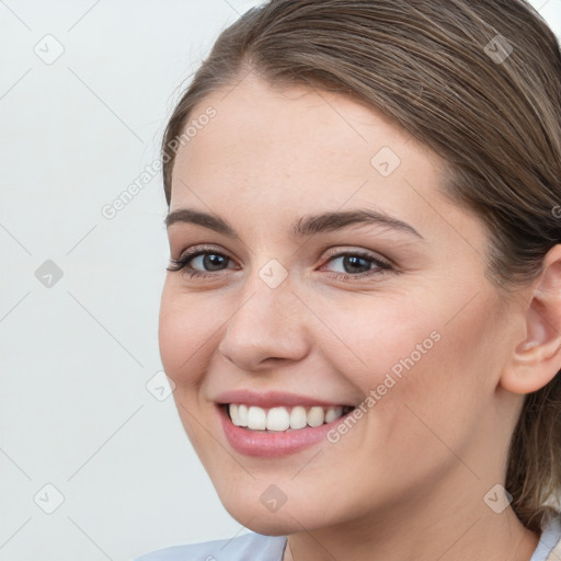 Joyful white young-adult female with medium  brown hair and grey eyes