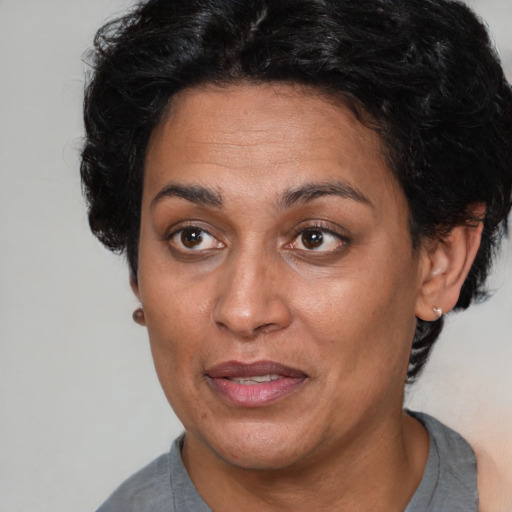 Joyful latino adult female with short  brown hair and brown eyes