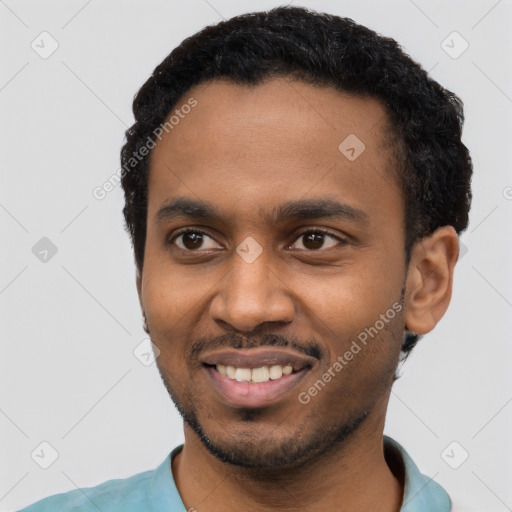 Joyful black young-adult male with short  black hair and brown eyes