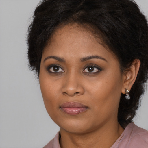 Joyful black young-adult female with long  brown hair and brown eyes