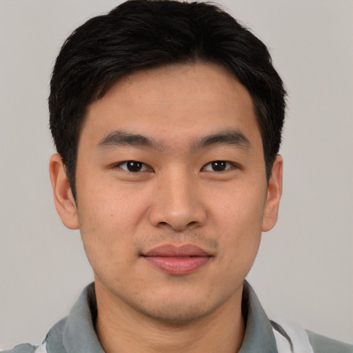 Joyful asian young-adult male with short  brown hair and brown eyes