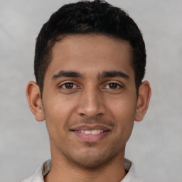 Joyful latino young-adult male with short  black hair and brown eyes