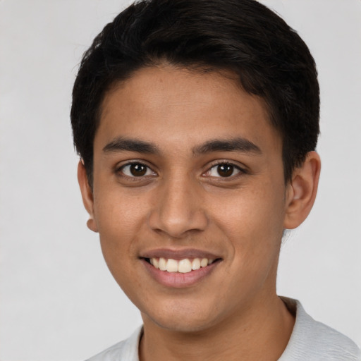 Joyful latino young-adult male with short  black hair and brown eyes