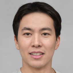 Joyful asian young-adult male with short  brown hair and brown eyes