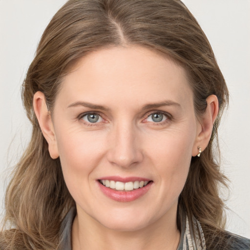 Joyful white young-adult female with long  brown hair and grey eyes