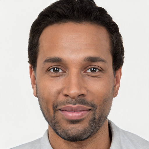 Joyful black young-adult male with short  black hair and brown eyes