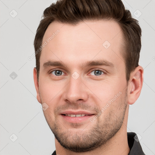 Joyful white young-adult male with short  brown hair and grey eyes