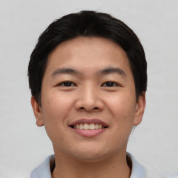 Joyful asian young-adult male with short  black hair and brown eyes