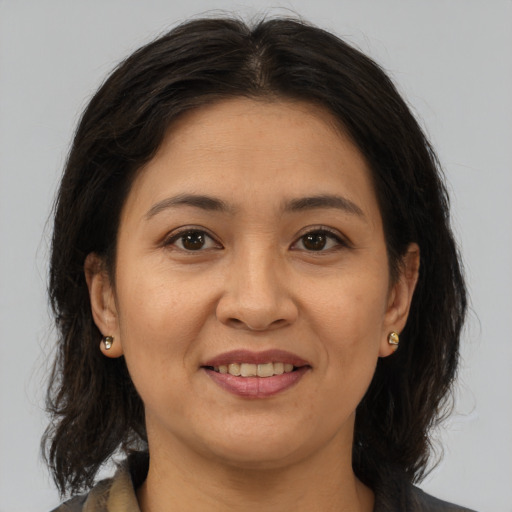 Joyful asian adult female with medium  brown hair and brown eyes