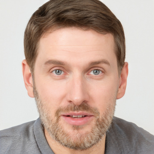 Joyful white adult male with short  brown hair and grey eyes