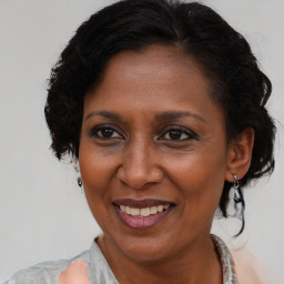 Joyful black adult female with medium  brown hair and brown eyes