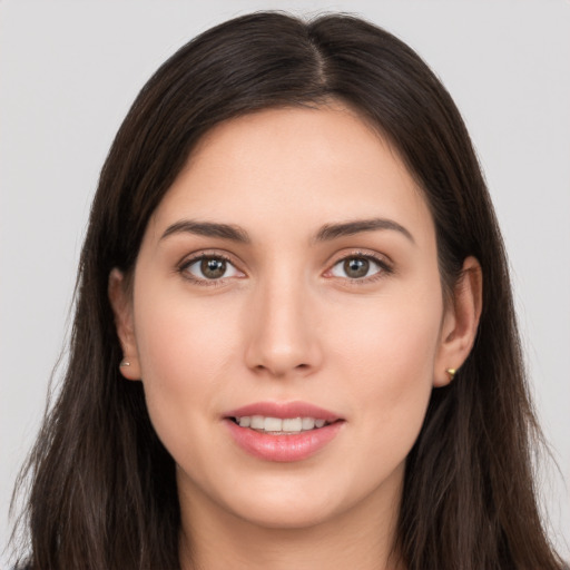 Joyful white young-adult female with long  brown hair and brown eyes