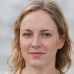 Joyful white young-adult female with medium  brown hair and blue eyes