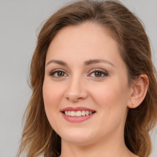 Joyful white young-adult female with long  brown hair and green eyes