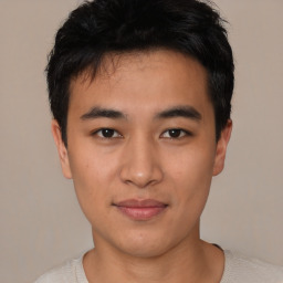 Joyful asian young-adult male with short  black hair and brown eyes