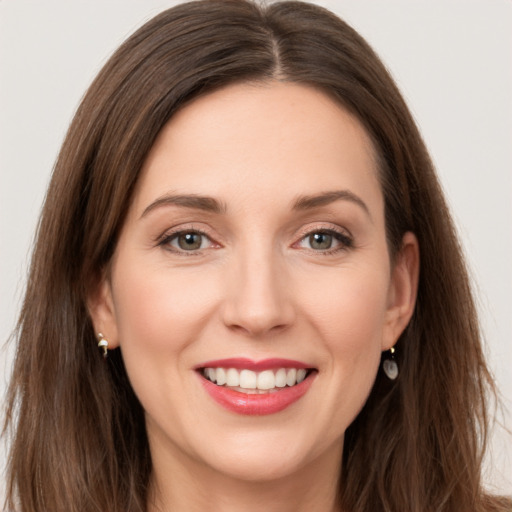 Joyful white young-adult female with long  brown hair and green eyes